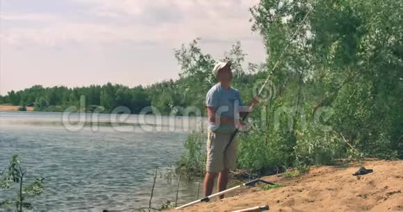 快乐父子正在钓鱼儿子帮爸爸把钓到的鱼拔出来拎着捕鱼的人快乐视频的预览图