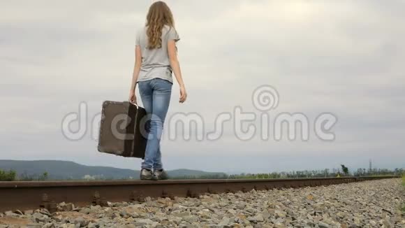 带着手提箱在铁路上行走的少女视频的预览图