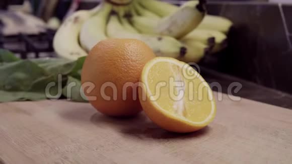 橙色和一半在切割板上背景香蕉和菠菜视频的预览图