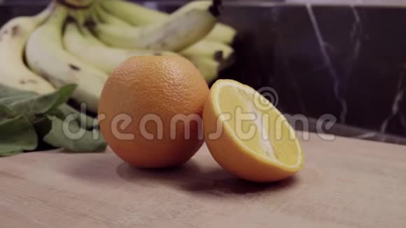 橙色和一半在切割板上背景香蕉和菠菜视频的预览图