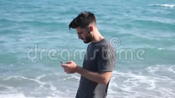海边的年轻人用电话发语音信息视频的预览图