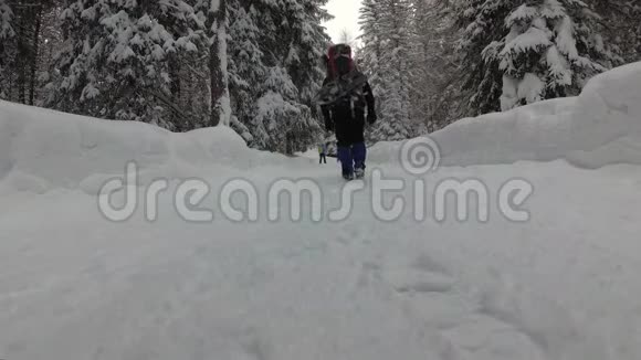 一个背包客正沿着雪山之路行走视频的预览图