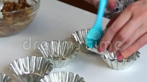 一个女人用葵花油金属形式润滑烘焙蛋糕使用特殊的刷子视频的预览图