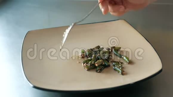 厨师把串豆放在餐厅的盘子里逐步烹饪菜肴的概念视频的预览图