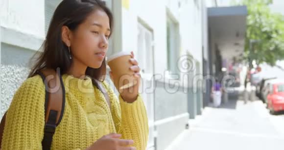 少女在人行道上喝咖啡视频的预览图