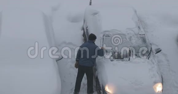 1男人把车从停车场的积雪中擦干净视频的预览图