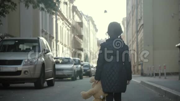 带着泰迪熊的小女孩独自走在街上视频的预览图