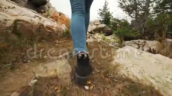 年轻女子穿着皮革登山靴徒步上山徒步行走的徒步旅行者女孩视频的预览图