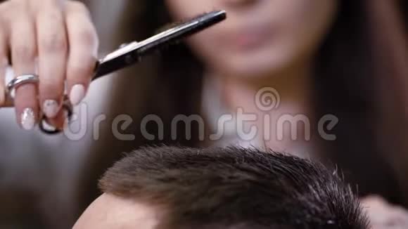 用梳子和锋利的专业发型师把客户的头发末端收起来视频的预览图