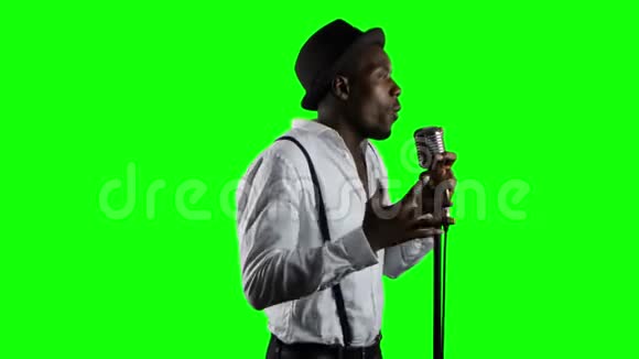男歌手在营业额的一半唱歌成麦克风和舞蹈绿色屏幕关门视频的预览图