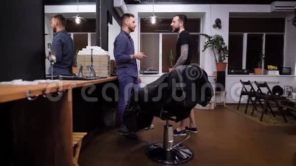 现代理发店的两个帅哥正在讨论未来的发型职业理发师穿着休闲服装视频的预览图