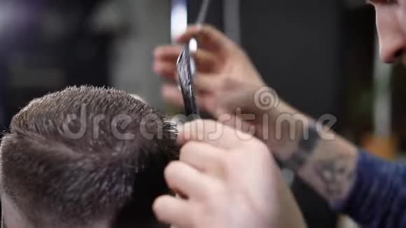 用锋利的专业剪刀将他的客户的男性头部和手收拢人类是视频的预览图
