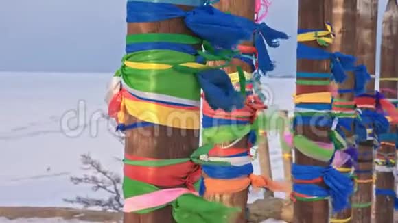 在贝加尔湖的圣地冬天有彩色丝带的佛教仪式杆神圣的地方木杆视频的预览图
