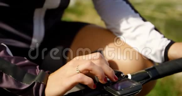 女骑自行车者在4k的屏幕上检查速度视频的预览图