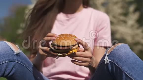成功的商务女性吃快餐汉堡芝士汉堡在公园里尽情享受休闲的自由时光视频的预览图