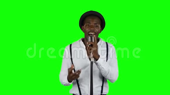 歌手唱成复古麦克风旋转和跳舞围绕他绿色屏幕视频的预览图
