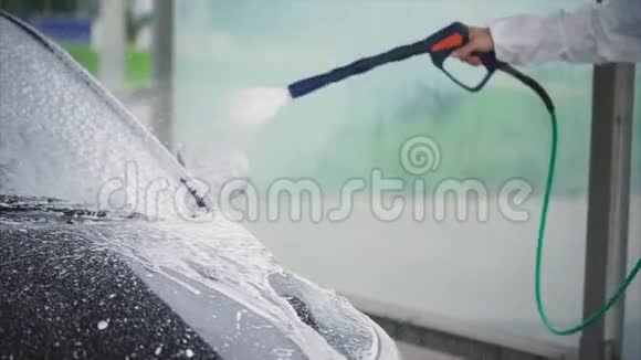男人在他的车上喷泡沫洗车自助服务视频的预览图