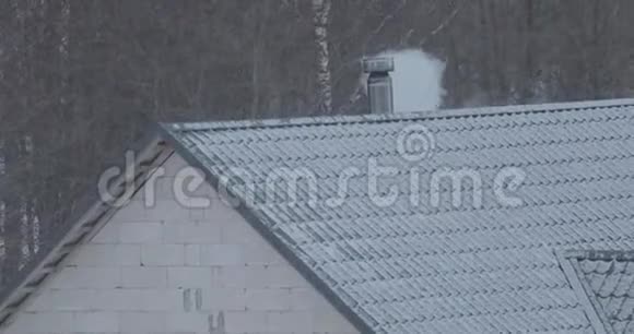 冬天烟从屋顶的烟囱里冒出来视频的预览图