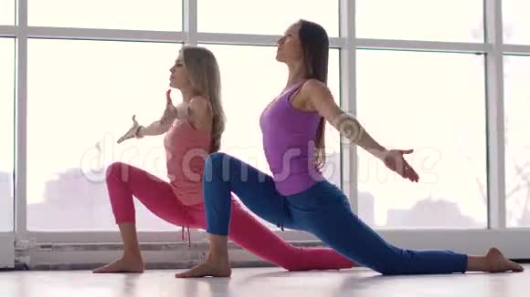 瑜伽女孩一起在大窗户背景下做瑜伽视频的预览图