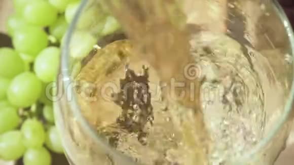 慢慢地饮料被漂亮地倒入玻璃杯中照相机移动到葡萄上视频的预览图