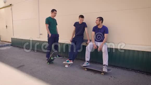三个朋友青少年在户外享受乐趣在滑板公园里参加运动微笑和聊天积极主动视频的预览图