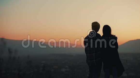 恋爱中的年轻夫妇在山上欣赏日落的剪影假期旅行浪漫求婚视频的预览图
