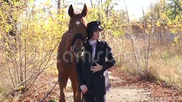 秋天一个穿着特别衣服和一匹棕色马的豪华女孩的肖像视频的预览图