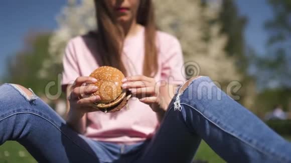 成功的商务女性吃快餐汉堡芝士汉堡在公园里尽情享受休闲的自由时光视频的预览图
