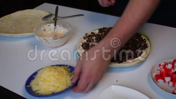 准备披萨这个人用蘑菇覆盖比萨饼的底部有一层厚厚的奶酪桌子旁边是其他的视频的预览图
