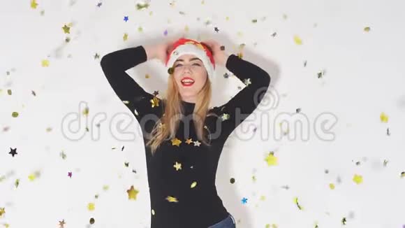 快乐快乐的女孩戴着红帽子圣诞老人在五彩的烟花下跳舞时玩得很开心视频的预览图