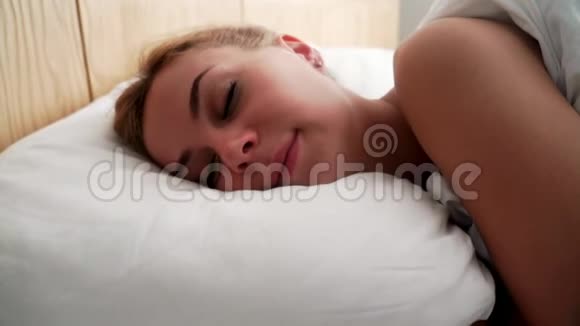 描绘睡在床上的年轻女人睡在枕头上的贴身女人视频的预览图