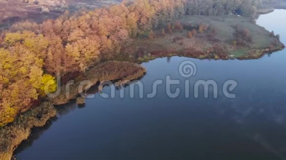 飞越一个湖水面上有雾早晨雾霭朦胧雾霭笼罩湖面秋天的薄雾秋天视频的预览图