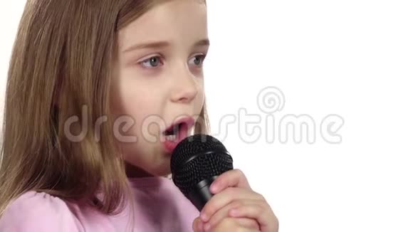 小女孩把歌唱到麦克风里白色背景快关门慢动作视频的预览图