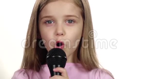 童女将歌曲唱入话筒白色背景快关门慢动作视频的预览图