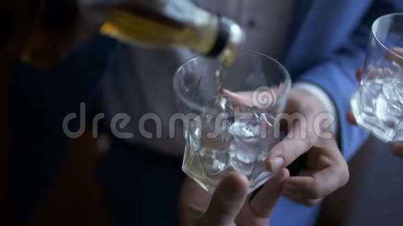 优雅的商人把威士忌倒进玻璃杯里视频的预览图