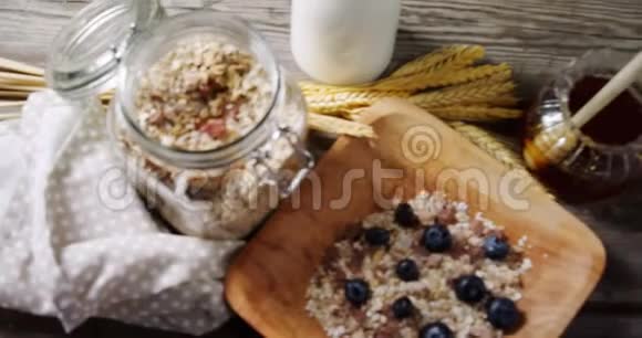 早餐谷类食品和木制桌子上的一罐蜂蜜视频的预览图