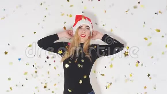 快乐快乐的女孩戴着红帽子圣诞老人在五彩的烟花下跳舞时玩得很开心视频的预览图