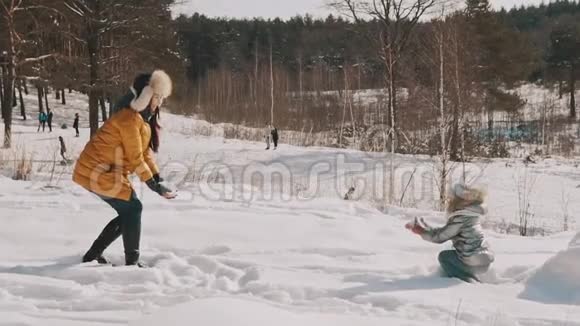 妈妈和小女儿慢动作玩雪冬季快乐休息视频的预览图