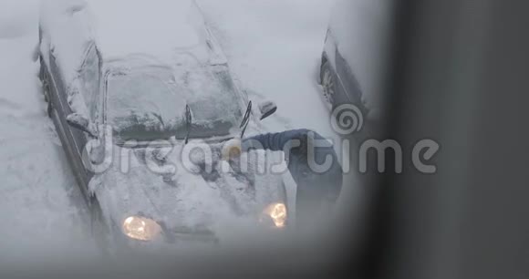 1男人把车从停车场的积雪中擦干净视频的预览图