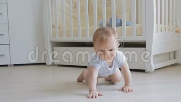 可爱的微笑宝宝爬在地板上朝镜头走去视频的预览图