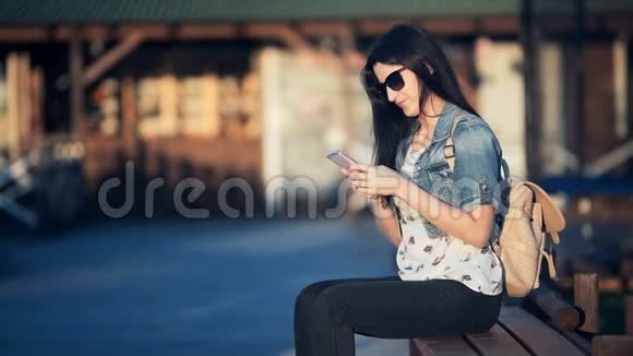 漂亮的女人带着智能手机在一家街头咖啡馆打短信视频的预览图