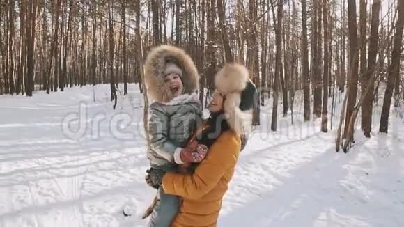 母亲和女儿在冬季公园享受阳光明媚的天气有乐趣的户外活动视频的预览图