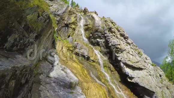 蓝色天空中的岩石中的漩涡瀑布白云背景阿尔泰山视频的预览图