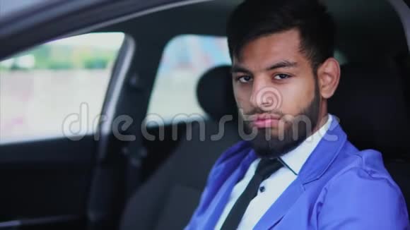 穿着正式西装的阿拉伯年轻人坐在车里他看起来很有表现力视频的预览图