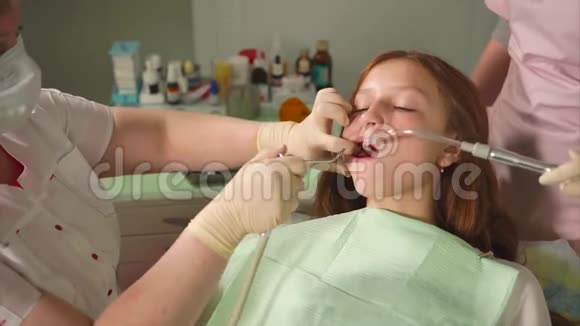 钻后少女患者牙科洗牙与助理一起工作视频的预览图