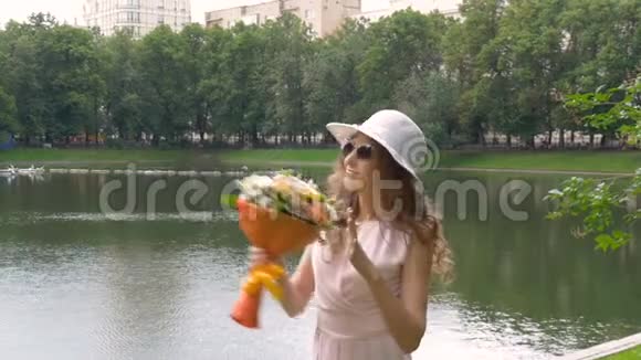一个美丽的女孩带着一束鲜花在舞蹈中旋转慢动作视频的预览图