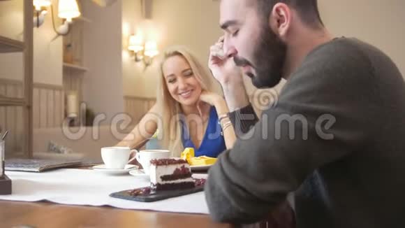 快乐的白种人夫妇在咖啡馆吃甜点和聊天视频的预览图