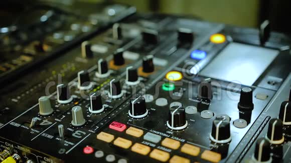 夜总会DJ播放混合声板控制台闪烁的灯光和按钮视频的预览图