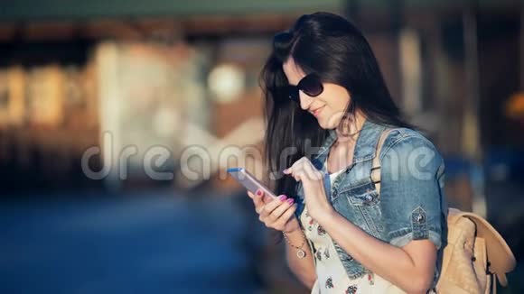 漂亮的女人带着智能手机在一家街头咖啡馆打短信视频的预览图