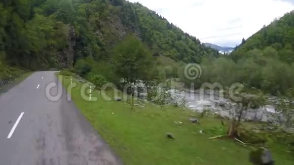 骑在蜿蜒的山路上沿着湍急的河流和陡峭的悬崖视频的预览图